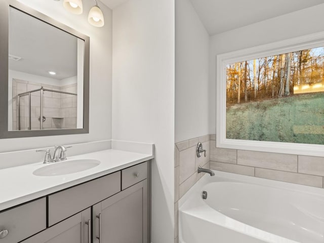 bathroom featuring separate shower and tub and vanity