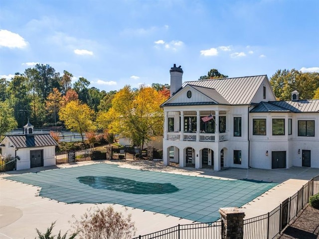 back of house with a covered pool and a patio