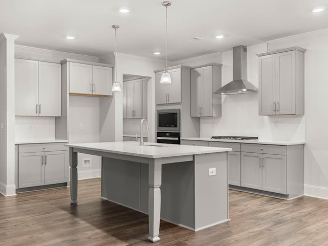 kitchen featuring gray cabinets, wall chimney exhaust hood, built in microwave, and sink