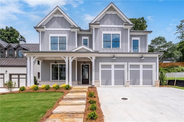 view of front of home with board and batten siding, concrete driveway, metal roof, an attached garage, and a standing seam roof