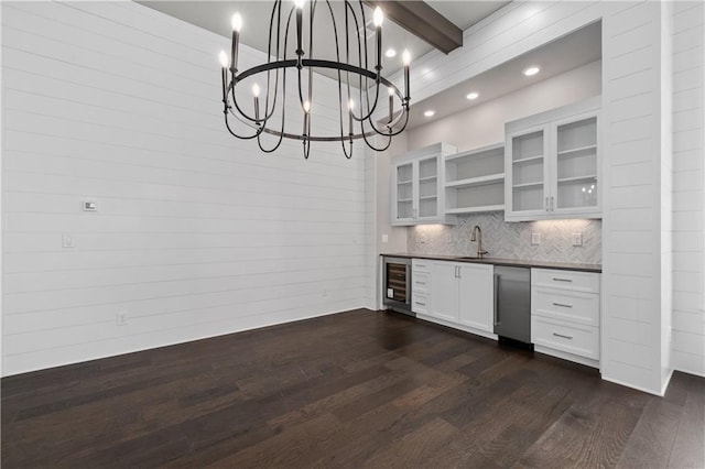 kitchen featuring open shelves, a sink, dark wood-type flooring, stainless steel dishwasher, and dark countertops