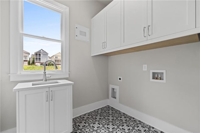 laundry area featuring hookup for a washing machine, baseboards, cabinet space, electric dryer hookup, and a sink