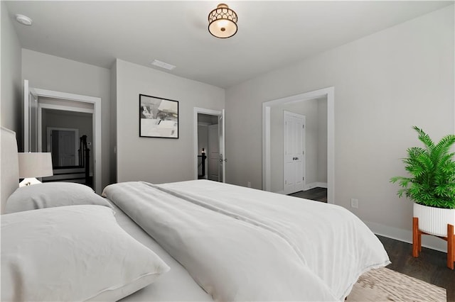 bedroom with dark wood-type flooring, visible vents, and baseboards