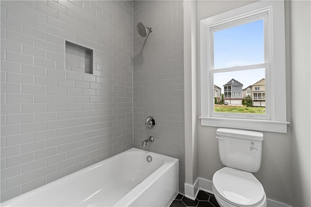 bathroom featuring tile patterned floors, tub / shower combination, toilet, and baseboards