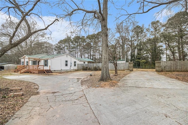 view of property exterior featuring driveway, crawl space, and fence