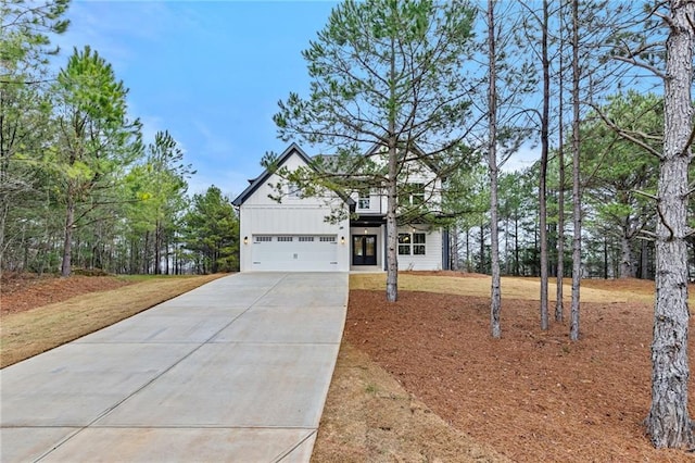 modern farmhouse with board and batten siding, driveway, and an attached garage