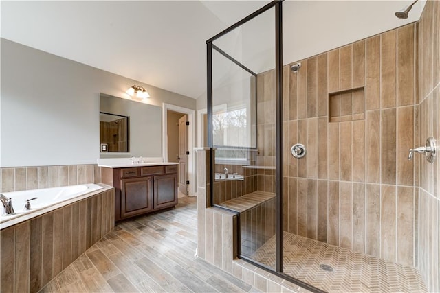 bathroom with vanity, independent shower and bath, lofted ceiling, and hardwood / wood-style floors