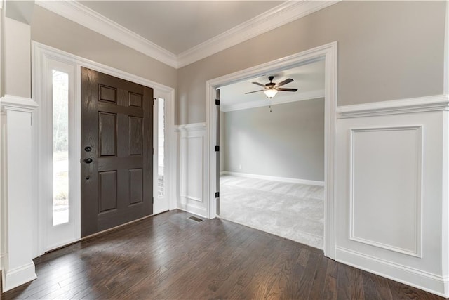 carpeted entryway featuring crown molding and ceiling fan