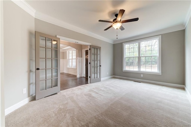 spare room with ceiling fan, carpet flooring, french doors, and crown molding