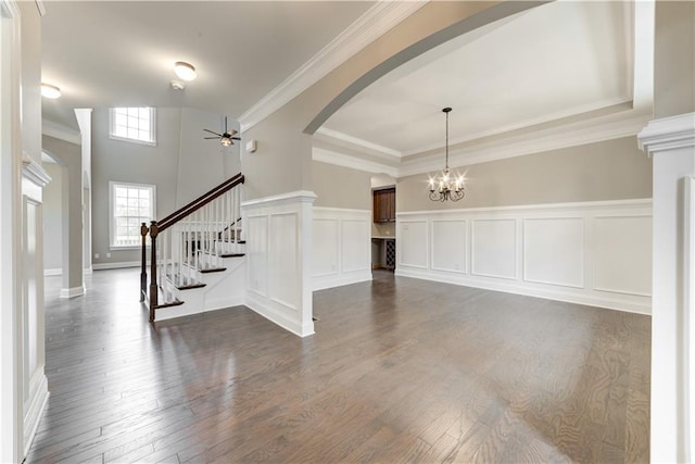 foyer entrance with dark hardwood / wood-style floors, ceiling fan with notable chandelier, ornamental molding, and a tray ceiling