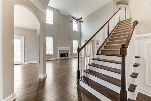 entrance foyer with a healthy amount of sunlight, ceiling fan, dark hardwood / wood-style floors, and a towering ceiling