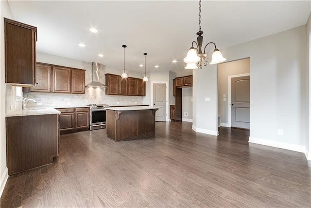 kitchen featuring wall chimney range hood, a center island, dark hardwood / wood-style floors, and stainless steel range oven