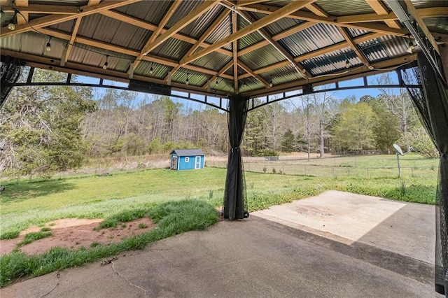 view of patio featuring a shed, an outdoor structure, and fence
