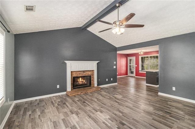 unfurnished living room featuring wood finished floors, ceiling fan, a fireplace, and visible vents