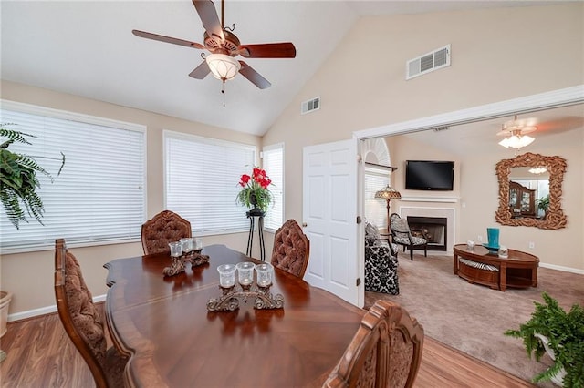 dining space with high vaulted ceiling, light hardwood / wood-style floors, and ceiling fan