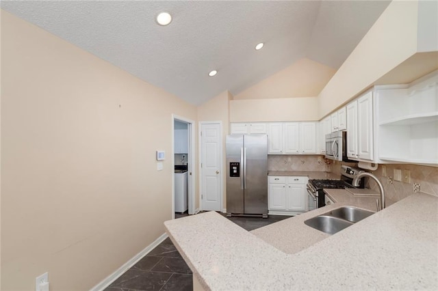 kitchen featuring sink, backsplash, stainless steel appliances, white cabinets, and vaulted ceiling