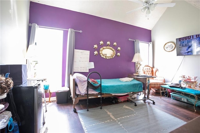 bedroom with high vaulted ceiling and wood finished floors