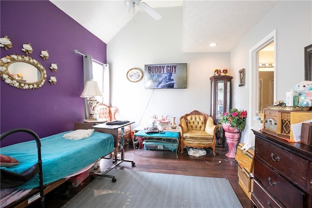 bedroom featuring a ceiling fan, a textured ceiling, wood finished floors, and vaulted ceiling