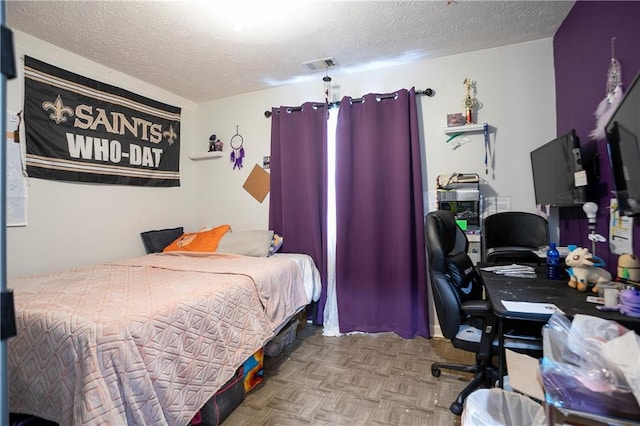 bedroom with a textured ceiling and visible vents