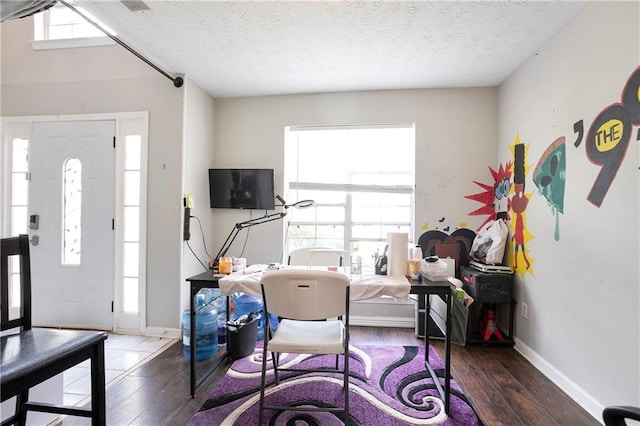 office area with a textured ceiling, baseboards, and hardwood / wood-style floors