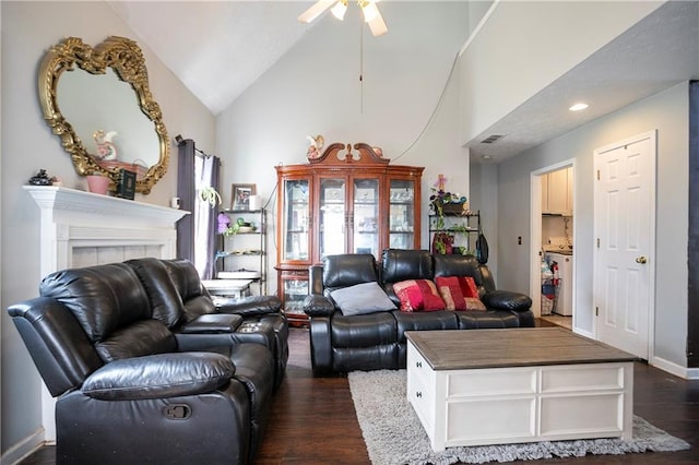 living area featuring a ceiling fan, visible vents, dark wood finished floors, a tile fireplace, and high vaulted ceiling