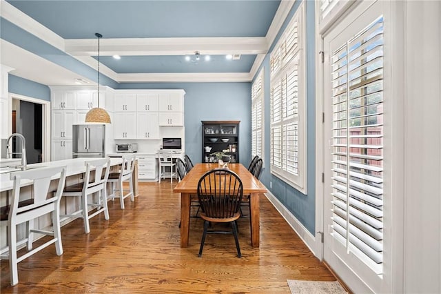 dining room with beam ceiling and light hardwood / wood-style flooring