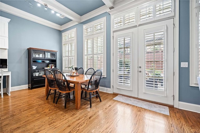 dining room featuring french doors, beam ceiling, light hardwood / wood-style floors, and crown molding