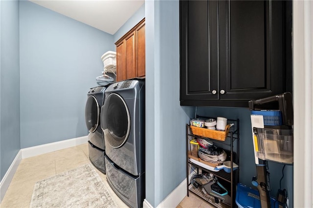 clothes washing area with light tile patterned flooring, cabinets, and separate washer and dryer