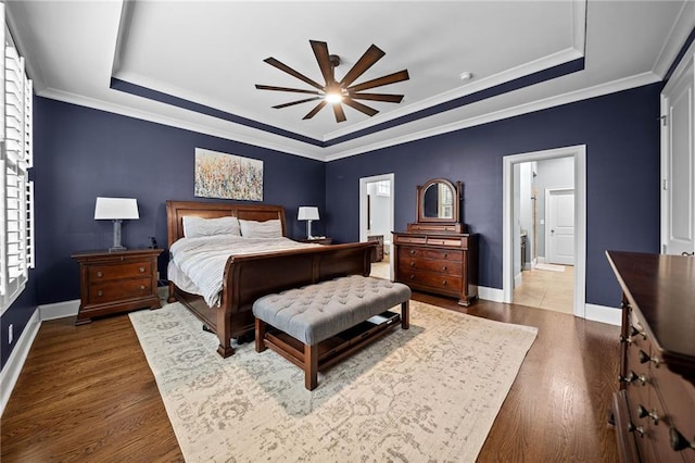 bedroom featuring ceiling fan, ornamental molding, and a tray ceiling