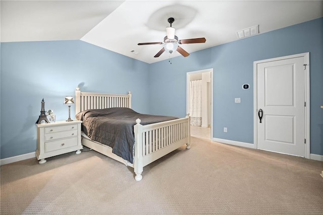 bedroom featuring light carpet, connected bathroom, lofted ceiling, and ceiling fan