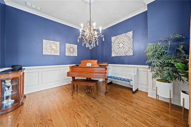 misc room with an inviting chandelier, ornamental molding, and hardwood / wood-style floors