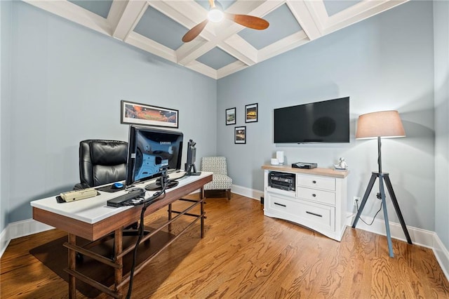 office space featuring ceiling fan, coffered ceiling, beam ceiling, and light hardwood / wood-style flooring