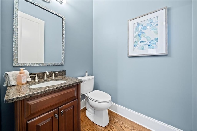 bathroom featuring vanity, hardwood / wood-style flooring, and toilet