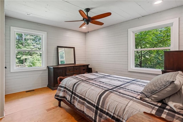 2121 Jep Wheeler Rd, Woodstock, GA 30188 - bedroom with light wood-type flooring, multiple windows, wood walls, ceiling fan, and recessed lighting