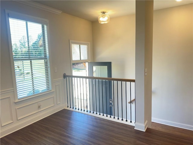 unfurnished room featuring ornamental molding and dark hardwood / wood-style flooring