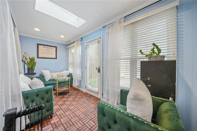 sitting room featuring brick floor, recessed lighting, ornamental molding, and a skylight