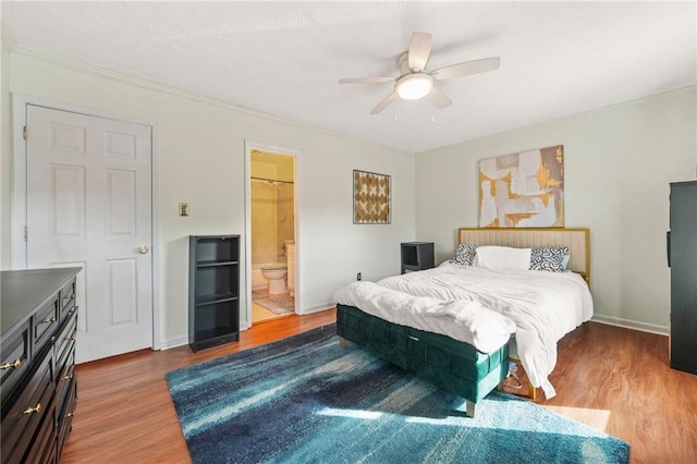 bedroom featuring ceiling fan, baseboards, a textured ceiling, and wood finished floors