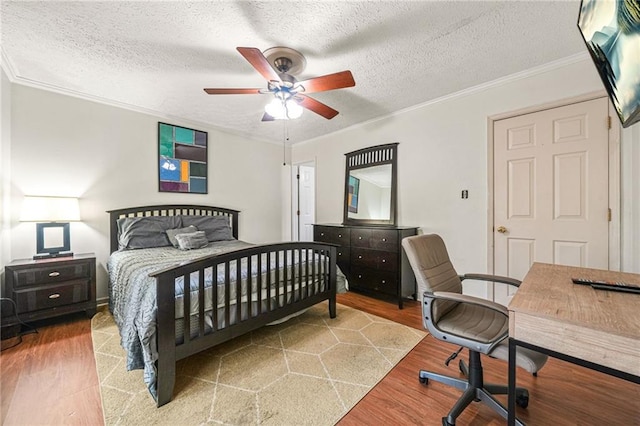 bedroom with a textured ceiling, ceiling fan, wood finished floors, and ornamental molding