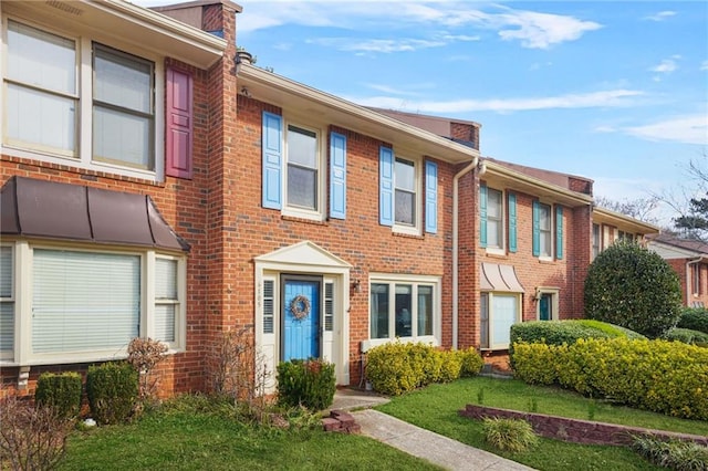 view of front of home featuring brick siding and a front yard