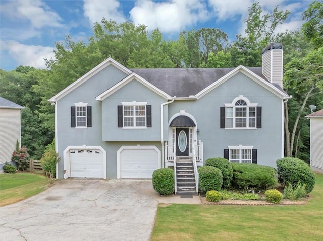 1735 Silver Way, Lithia Springs, GA 30122 - split foyer home featuring a chimney, a garage, stucco siding, concrete driveway, and a front yard