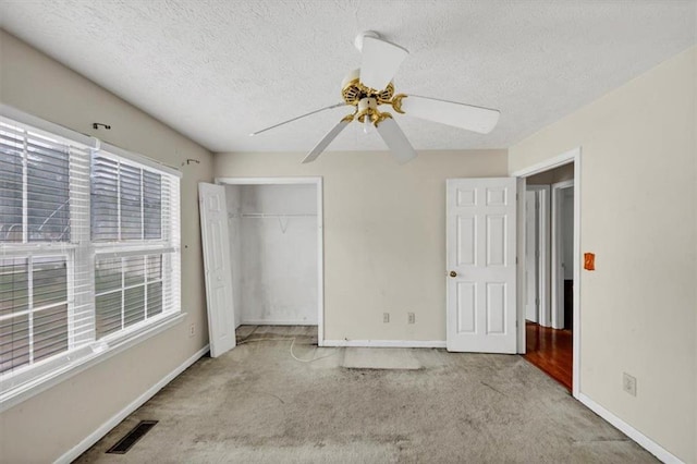 1735 Silver Way, Lithia Springs, GA 30122 - unfurnished bedroom with carpet flooring, a closet, a textured ceiling, and a ceiling fan