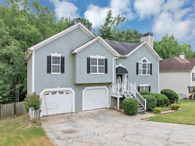 1735 Silver Way, Lithia Springs, GA 30122 - bi-level home with a chimney, a garage, stucco siding, and concrete driveway