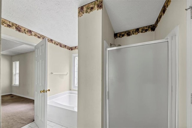 1735 Silver Way, Lithia Springs, GA 30122 - bathroom with a textured ceiling, a shower stall, plenty of natural light, a bath, and tile patterned flooring