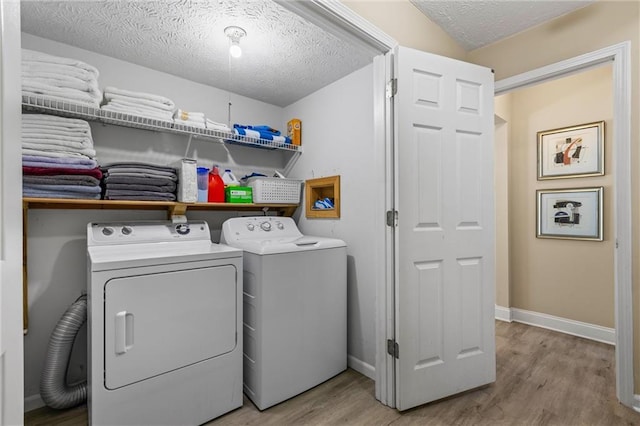 185 Fox Run, Loganville, GA 30052 - laundry area featuring wood finished floors, separate washer and dryer, and a textured ceiling