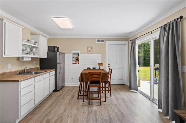 185 Fox Run, Loganville, GA 30052 - kitchen featuring open shelves, freestanding refrigerator, light wood-style floors, white cabinetry, and ornamental molding