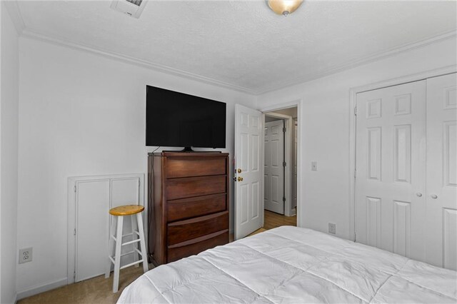 185 Fox Run, Loganville, GA 30052 - bedroom featuring crown molding, a closet, and a textured ceiling