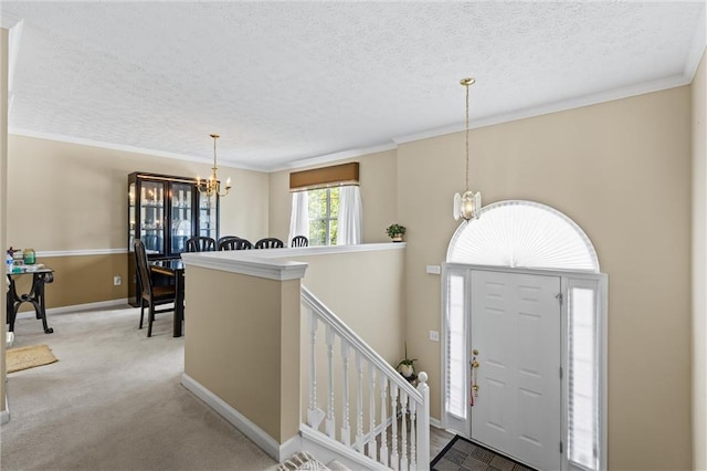 185 Fox Run, Loganville, GA 30052 - carpeted entryway with a chandelier, a textured ceiling, and ornamental molding