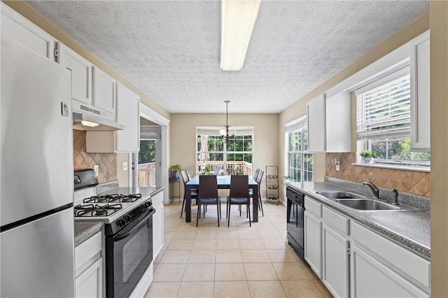 185 Fox Run, Loganville, GA 30052 - kitchen with black appliances, under cabinet range hood, light tile patterned flooring, decorative backsplash, and a textured ceiling