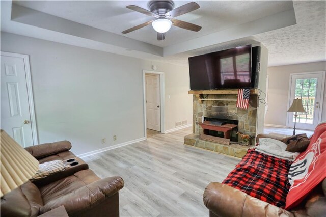 1638 River Trce, Auburn, GA 30011 - living area with a raised ceiling, a ceiling fan, a stone fireplace, baseboards, and wood finished floors