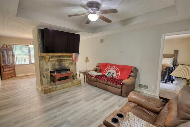 1638 River Trce, Auburn, GA 30011 - living area featuring a raised ceiling, a textured ceiling, baseboards, light wood-style floors, and a ceiling fan
